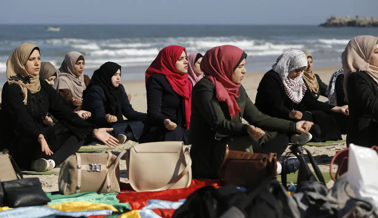 Sejumlah wanita Palestina berlatih yoga di pantai di Gaza City (3/3/2020). Pelatihan yoga tersebut diselenggarakan oleh Positive Energy Club. (AFP Photo/Mohammed Abed)