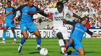 Gelandang Lyon, Michael Essien, berusaha melewati hadangan bek Auxerre, Jean-Sebastien Jaures. Karier Essien mulai berkembang saat dirinya hijrah dari Bastia ke Lyon pada tahun 2003 lalu. (AFP/Pascal George)