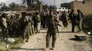 Anggota Syrian Democratic Forces beristirahat saat memburu militan ISIS di kantong terakhir kekhalifahan di Baghouz, Suriah, Selasa (19/2). Sebelumnya, ISIS menguasai area seluas Inggris Raya dan memerintah lebih dari 10 juta orang. (Delil souleiman/AFP)