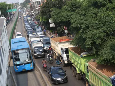 Kendaraan terjebak kemacetan di Jalan Sultan Agung, Jakarta, Selasa (8/8). Banyaknya truk proyek pembangunan Pasar Rumput menyebabkan kemacetan parah di kawasan tersebut karena parkir hingga menutup sebagian jalur. (Liputan6.com/Immanuel Antonius)