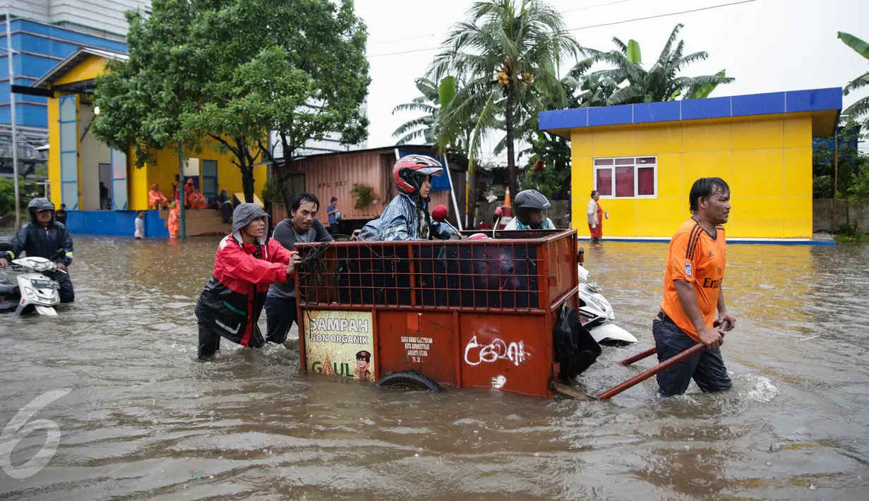 Penyedia jasa gerobak mengangkut warga dan motornya untuk menyeberangi banjir di Jalan Gunung Sahari, Jakarta Pusat, Selasa (21/2). Hujan deras yang mengguyur sejak Selasa dini hari membuat sebagian wilayah di Jakarta banjir. (Liputan6.com/Faizal Fanani)