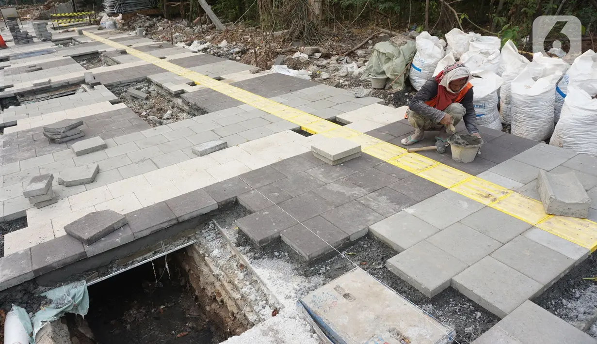 Pekerja menyelesaikan proyek revitalisasi trotoar di kawasan Kemang, Jakarta, Kamis (31/10/2019). Revitalisasi trotoar Kemang yang ditargetkan rampung pada November 2019 ini untuk memaksimalkan kenyamanan pejalan kaki dan mendongkrak aktivitas ekonomi di kawasan tersebut. (Liputan6.com/Angga Yuniar)
