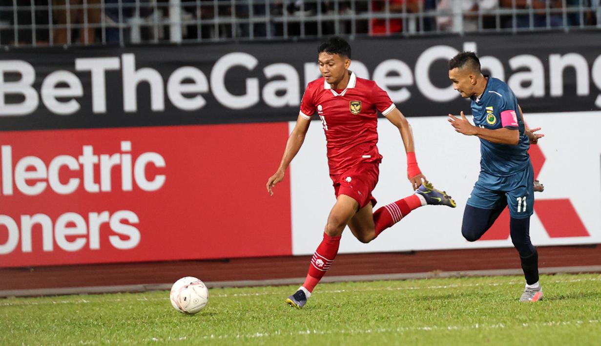 Pesepak bola Timnas Indonesia Dendy Sulistyawan (kiri) menggiring bola dengan dibayangi pesepak bola Brunei Darussalam Najib Tarif dalam pertandingan Grup A Piala AFF 2022 di Stadion Kuala Lumpur, Malaysia, Senin (26/12/2022). Indonesia mengalahkan Brunei Darussalam dengan skor 7-0. (Liputan6.com/PSSI)