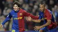 Bintang Barcelona, Lionel Messi, bersama rekannya Thierry Henry merayakan gol yang dicetaknya ke gawang Lyon pada babak grup Liga Champions di Stadion Camp Nou, Barcelona, Rabu (11/3/2009). (AFP/Philippe Desmazes)