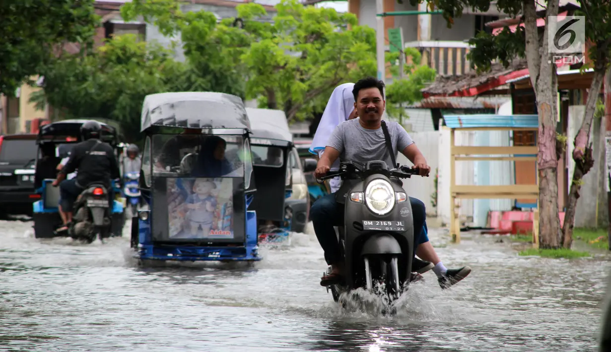 Kendaraan melintasi banjir yang merendam wilayah Kota Gorontalo, Selasa (30/4/2019). Hujan yang mengguyur wilayah Kabupaten Bone Bolango mengakibatkan empat desa di Kecamatan Suwawa Selatan, dan Bulango Timur Bone Bolango banjir. (Liputan6.com/Arfandi Ibrahim)