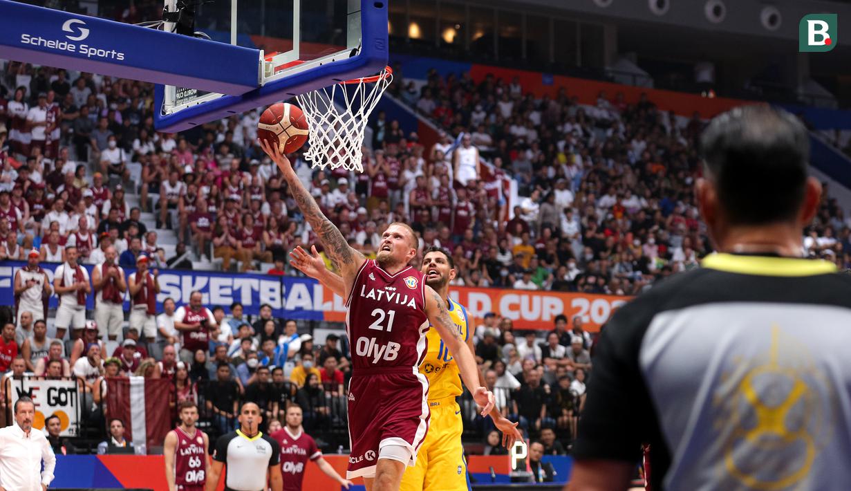 Pebasket Latvia, Aigars Skele (kiri) melakukan lay up pada laga Grup L Piala Dunia FIBA 2023 antara Latvia melawan Brasil di Indonesia Arena, Senayan, Jakarta, Minggu (03/09/2023). Latvia menang dengan skor 104-84. (Bola.com/Bagaskara Lazuardi)
