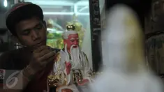 Pegawai toko penjual patung saat melakukan proses pengecetan di kawasan Medan Glodok Jakarta Barat, Kamis, (21/01).  Patung - patung ini mulai dicari pelanggan dalam menyambut hari raya Imlek. (Liputan6.com/Faisal R Syam)