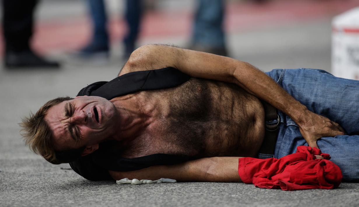 Seorang penjarah toko elektronik menjerit kesakitan setelah kakinya oleh polisi sipil di Vitoria, negara bagian Espirito Santo, Brasil, (7/2). Kejahatan yang meningkat membuat polisi menembak para penjarah. (AP Photo / Diego Herculano)