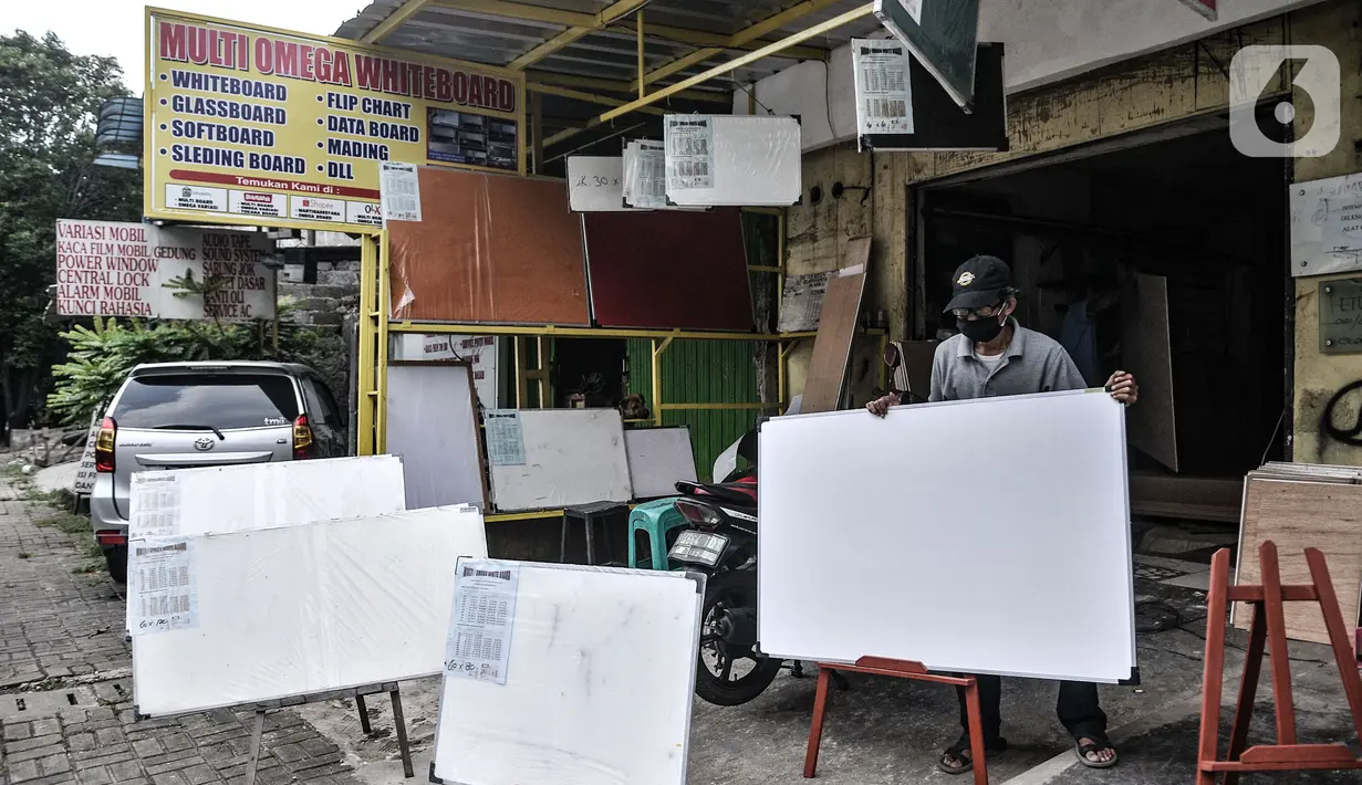 Pekerja merapikan papan tulis yang dipajang di depan toko di kawsan Jakarta, Rabu (3/3/2021). Sempat terpuruk di awal pandemi Covid-19 akibat ditiadakannya kegiatan belajar di sekolah, industri papan tulis milik Ganda (45) ini menyiasati penjualan melalui e-Commerce. (merdeka.com/Iqbal S Nugroho)