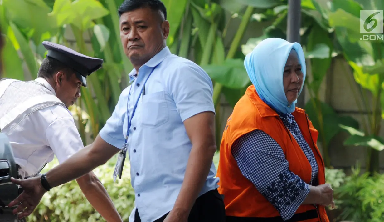 Panitera Pengadilan Negeri Tangerang Tuti Atika keluar dari mobil dikawal petugas menuju ruang pemeriksaan di gedung KPK, Jakarta, Kamis (29/03). (Merdeka.com/Dwi Narwoko)