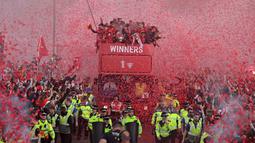Ribuan fans Liverpool memadati jalan-jalan kota untuk menyambut tim kebanggaan mereka yang melakukan parade di atas bus terbuka pada Minggu (29/05/2022) waktu setempat. Musim ini, The Reds berhasil meraih dua trofi yaitu Piala FA dan Piala Liga Inggris. (AFP/Oli Scarff)