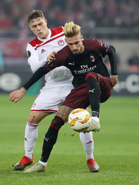 Pemain Olympiakos Piraeus, Leonardo Koutris berusaha merebut bola dari pemain AC Milan, Samuel Castillejo pada laga keenam Grup F Liga Europa di Stadion Georgios Karaiskakis, Kamis (13/12). AC Milan takluk 1-3 dari Olympiacos. (AP/Petros Giannakouris)