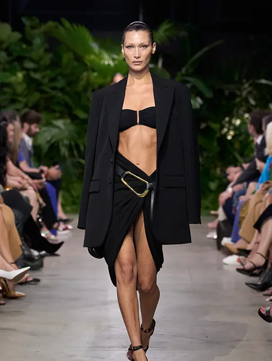Misalnya saja Bella Hadid yang tampil mengenakan oversize blazer dengan bra sebagai inner, dipadukan skirt dan belt keemasan besar. Michael Kors