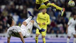 Cristiano Ronaldo melakukan tendangan salto saat dihadang pemain Villarreal, Eric Bally, pada lanjutan La Liga Spanyol di Stadion Santiago Bernabeu, Madrid, Rabu (20/4/2016) atau Kamis dini hari WIB. (AFP/Javier Soriano)