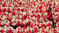 Pekerja mengemas paket bantuan sosial (bansos) di Gudang Food Station Cipinang, Jakarta, Rabu (22/4/2020). Pemerintah pusat menyalurkan paket bansos selama tiga bulan untuk mencegah warga mudik dan meningkatkan daya beli selama masa pandemi COVID-19. (Liputan6.com/Johan Tallo)