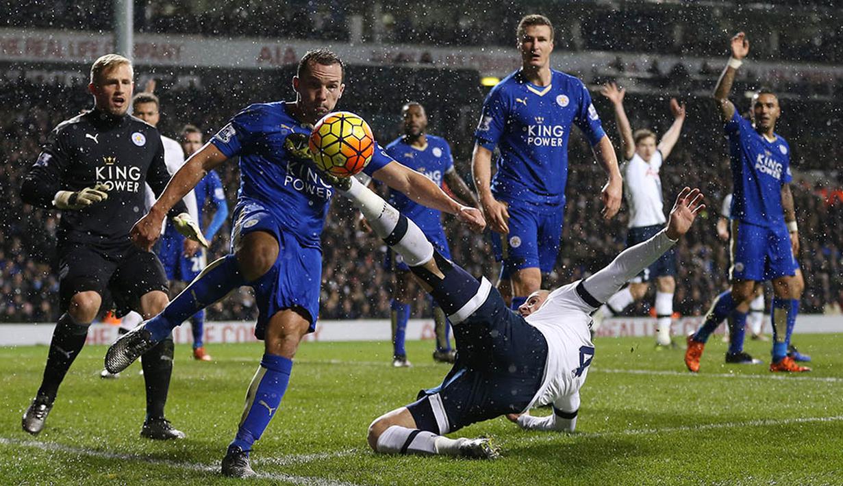 Pemain Tottenham, Toby Alderweireld, menendang bola dihalangi pemain Leicester, Danny Drinkwater, pada laga Liga Premier Inggris di Stadion White Hart Lane, Inggris, Rabu (13/1/2016). Leicester berhasil menang 1-0. (AFP/Matthew Childs)