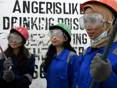 Foto pada 26 Januari 2019 menunjukkan seorang mahasiswa, Genta Kalbu Tanjung (kiri) bersama dua temannya setelah sesi permainan di Temper Clinic, Jakarta. Sesuai namanya, Temper Clinic memang memberikan tempat untuk menyalurkan amarah. (GOH Chai Hin/AFP)