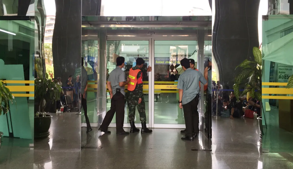 Sejumlah Orang berkumpul di depan pintu masuk Rumah Sakit Phramongkutklao, Bangkok, (22/5). Pengeboman terjadi bertepatan dengan peringatan tiga tahun kudeta militer di Negeri Gajah Putih tersebut. (AP Photo/Sakchai Lalit)