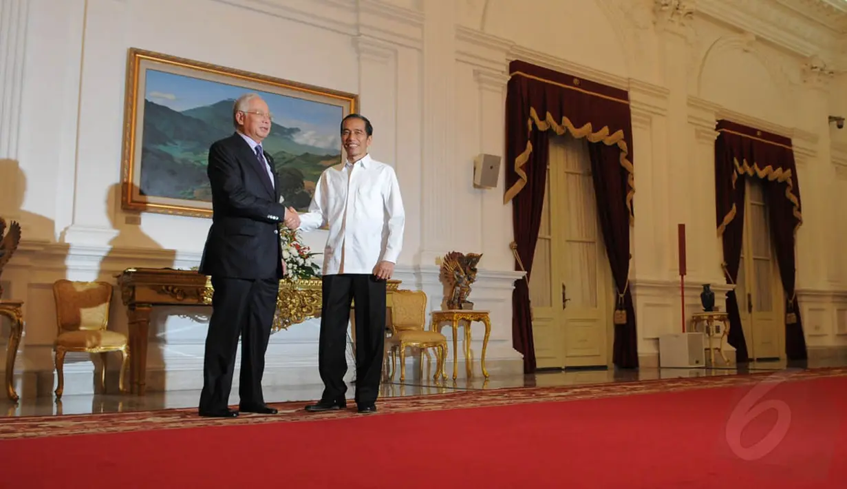 Presiden Jokowi menemui Perdana Menteri Malaysia Najib Razak dengan busana khasnya, kemeja putih lengan panjang tanpa dasi dan jas, Jakarta, (20/10/14). (Liputan6.com/Herman Zakharia)