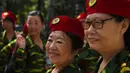 Sejumlah wanita lansia tampil mengenakan pakaian bergaya militer berfoto bersama usai mengikuti Hari Kebugaran Nasional di Beijing, Tiongkok (8/8). (AFP Photo/Greg Baker)