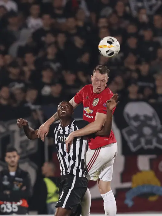 Bek Manchester United, Phil Jones berebut bola udara dengan Partizan Belgrade, Umar Sadiq pada pertandingan lanjutan Grup L Liga Europa di stadion Partizan di Belgrade, Serbia (24/10/2019). MU menang tipis 0-1 atas Partizan Belgrade. (AP Photo/Darko Vojinovic)