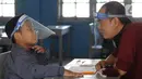 Calon siswa dengan menggunakan pelindung wajah mengikuti psikotes di SD Islam Al-Hidayah, Cinere, Depok, Senin (6/7/2020). Tes psikologi itu sebagai syarat kesiapan masuk jenjang pendidikan sekolah dasar jelang pelaksanaan tahun ajaran baru 2020/2021 pada 13 Juli mendatang. (merdeka.com/Arie Basuki)