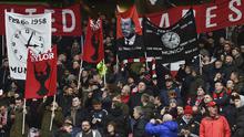 Fans membentangkan spanduk memperingati 60 tahun tragedi Munich Air 1958 saat laga  Manchester United melawan Huddersfield Town di Old Trafford, Manchester, (3/2/2018). MU menang 2-0. (AFP/Paul Ellis)