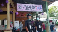 Tempat pemungutan suara (TPS) 15 Limau Manis Selatan, Kecamatan Pauh, Kota Padang Sumatera Barat pada Pilkada serentak 9 Desember 2020, petugas di lokasi itu mengenakan helm berbentuk virus corona sambil melayani para pemilih yang datang. (Liputan6.com/ Novia Harlina)