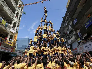 Ribuan umat Hindu membentuk piramida manusia untuk mencapai dan memecahkan dahi-handi (pot yang terbuat dari tanah liat) pada Festival Janmashtami di Mumbai, India, 6 September 2015. Festival ini menandai kelahiran dewa Krishna (REUTERS/Danish Siddiqui)