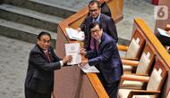 Ketua Komisi III DPR Bambang Wuryanto saat memberikan dokumen laporan Komisi III kepada Menteri Hukum dan HAM Yasonna Laoly saat rapat paripurna DPR di Jakarta, Selasa (6/12/2022). DPR RI resmi mengesahkan Rancangan Undang-Undang Kitab Undang-Undang Hukum Pidana (RUU KUHP) menjadi Undang-Undang. (Liputan6.com/Angga Yuniar)