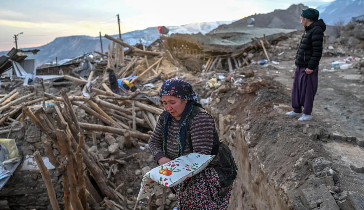 Sejumlah wanita berdiri di atas reruntuhan rumah mereka di desa Yaylakonak distrik Adiyaman, Turki, Minggu (19/2/2023). Gempa bumi berkekuatan 7,8 magnitudo melanda dekat Gaziantep, Turki, pada dini hari tanggal 6 Februari, diikuti oleh gempa susulan berkekuatan 7,5 magnitudo setelah tengah hari. Gempa bumi tersebut menyebabkan kehancuran yang meluas di Turki Selatan dan Suriah Utara dan telah menewaskan lebih dari 40.000 orang. (BULENT KILIC/AFP)
