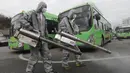Pekerja mengenakan pakaian pelindung saat menyemprotkan Disinfektan sebagai tindakan pencegahan virus corona COVID-19 di tempat parkir bus di Seoul, Korea Selatan, Rabu, (26/2/2020). Jumlah infeksi corona di Korea Selatan melonjak lagi pada Rabu (26/2). (AP Photo/Ahn Young-joon)
