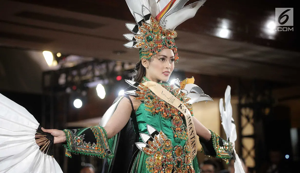 Finalis Kalimantan Barat, Vegiananda menampilkan bakat dalam balutan busana tradisional dari daerahnya saat babak preliminary Miss Grand Indonesia 2018 di Jakarta, Senin (16/7). Sebanyak 30 finalis mencapai babak preliminary. (Liputan6.com/Faizal Fanani)