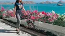 Berlatarkan keindahan laut dan pulau-pulau di Labuan Bajo, Aaliyah tampak santai dengan menggunakan baju kaus berwarna biru dengan jeans gelap. Rambutnya yang dibiarkan tergerai membuatnya semakin memesona. (Liputan6.com/IG/@aaliyah.massaid)