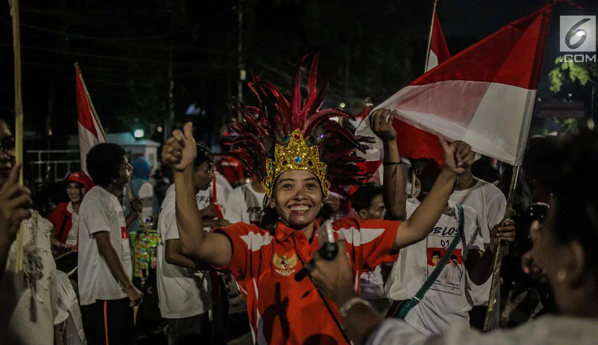 Pendukung pasangan Capres 01 Joko Widodo-Ma'aruf Amin berkumpul di kawasan Tugu Proklamasi, Jakarta, Rabu (17/4). Pendukung melakukan pawai usai mengetahui hasil hitung cepat dari berbagai lembaga survey yang mengeluarkan hasil Capres 01 mengungguli Capres 02. (Liputan6.com/Faizal Fanani)