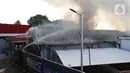 Petugas memadamkan api saat terjadi kebakaran di Gudang JNE Express, Jalan Pekapuran Raya, Depok, pada Senin (12/9/2022). Kepala Bidang Pengendalian Operasional Dinas Pemadam Kebakaran dan Penyelamatan Kota Depok Welman Naipospos mengatakan, kebakaran di gudang JNE Depok ini diduga terjadi akibat korsleting atau hubungan pendek arus listrik. (Liputan6.com/Herman Zakharia)