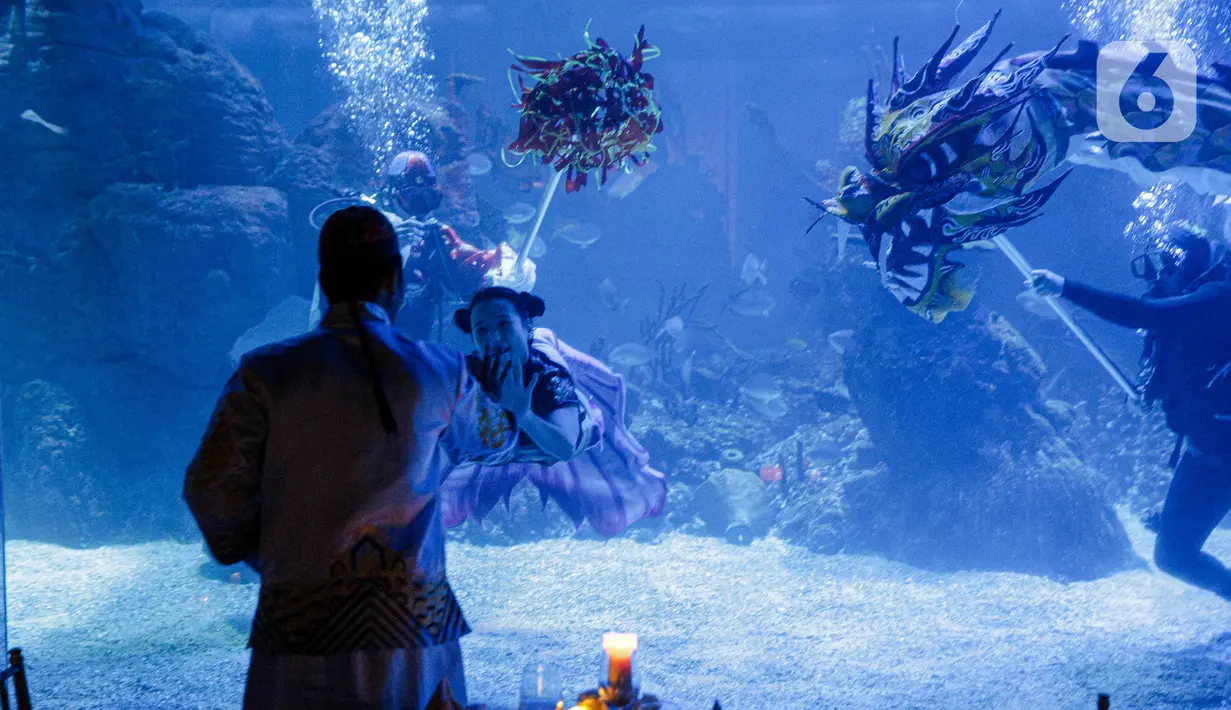 Aksi treatrikal Liong dan Putri Duyung  bawah air di Jakarta Aquarium & Safari (JAQS), Jakarta, Kamis (27/1/2022). Kegiatan dalam rangka memeriahkan Tahun Baru Imlek dan menjadi tujuan liburan akhir pekan panjang di dalam kota Jakarta yang aman dan nyaman. (Liputan6.com/Faizal Fanani)