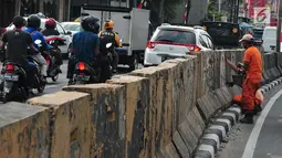 Kendaraan melintas saat anggota PPSU melakukan pengecatan trotoar di Kawasan Jakarta, Selasa (1/8). Selain untuk memperindah Ibu Kota Jakarta, pengecatan tersebut dilakukan untuk menyambut Hari Kemerdekaan RI ke-72. (Liputan6.com/Helmi Afandi)