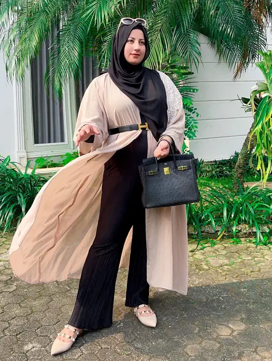 Kombinasi long outer warna nude dengan celana hitam beri kesan elegan pada tampilan. [Foto: IG/tasyiiathasyia].