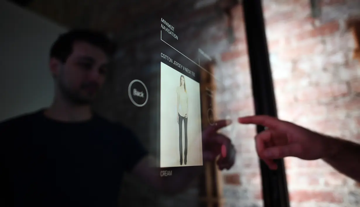 Peneliti Oak Labs, Wesley Bliss saat menggunakan cermin pintar Oak Fitting Room di sebuah butik, New York, AS (7/2). Oak Fitting Room merupakan kamar ganti yang dilengkapi cermin pintar. (AFP Photo / Jewel Samad)