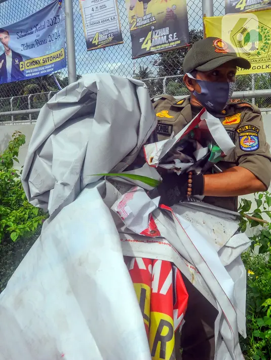 <p>Petugas membawa APK Pemilu 2024 saat melakukan penertiban. (merdeka.com/Arie Basuki)</p>