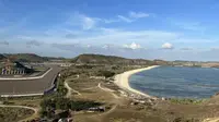 Suasana Sirkuit Mandalika yang berbatasan dengan pantai pesisir Selatan Pulau Lombok dilihat dari atas Bukit Seger, Lombok, Jumat (11/8/2023) yang menjadi spot menarik menyaksikan balapan. (Bola.com/Iqri Widya)