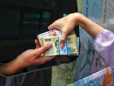 Warga menukarkan uang tunai baru di layanan kas keliling Bank Indonesia di Pasar Kopro, Jakarta Barat, Rabu (29/3/2023). (Liputan6.com/Angga Yuniar)