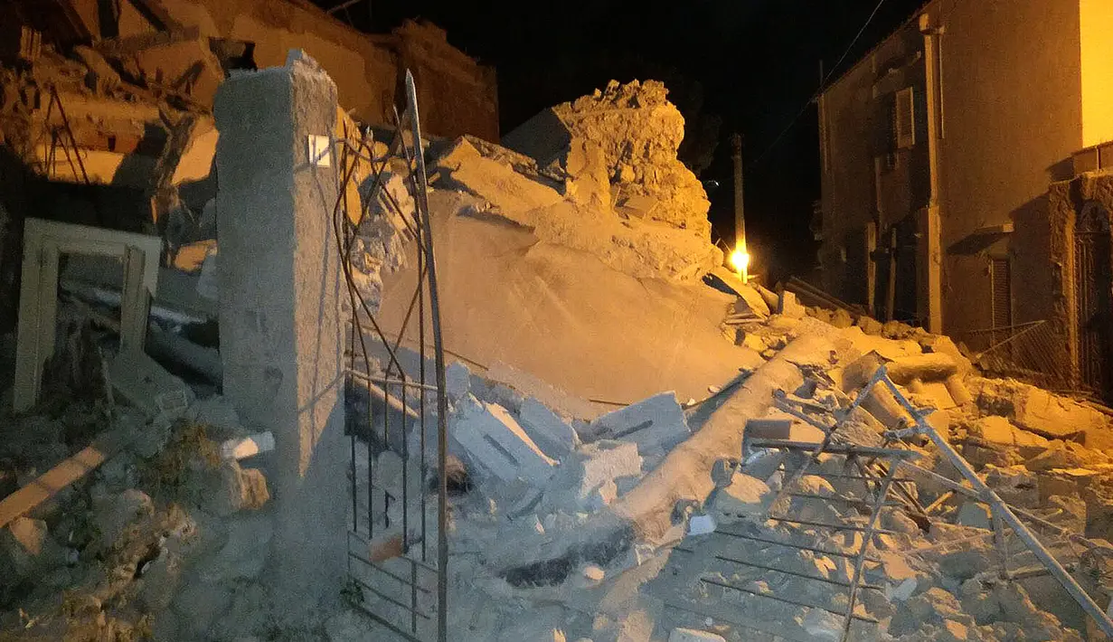 Sejumlah orang berdiri di dekat bangunan yang rusak akibat gempa di Pulau Ischia, Italia (21/8). Akibat gempa tersebut satu orang tewas dan tujuh lainnya hilang. (@ Percy80 via AP)
