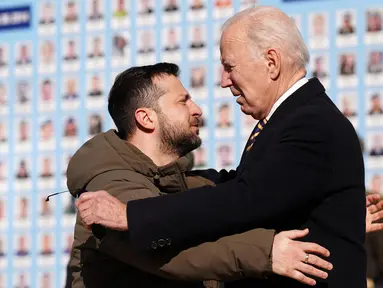 Presiden AS Joe Biden (kanan) dipeluk oleh Presiden Ukraina Volodymyr Zelensky (kiri) saat berkunjung di Kyiv, Ukraina pada 20 Februari 2023. Presiden AS Joe Biden melakukan kunjungan mendadak ke Kyiv pada 20 Februari 2023, menjelang peringatan satu tahun invasi Rusia ke Ukraina. Zelensky menyambut gembira kunjungan Presiden AS Joe Biden. (Dimitar DILKOFF/AFP)