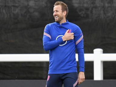Striker timnas Inggris Harry Kane tertawa selama sesi latihan tim di St George's Park di Burton-upon-Trent, Senin (13/6/2022). Inggris akan bersua Hungaria pada matchday 4 Grup 3 UEFA Nations League A di Molineux Stadium, Rabu 15 Juni 2022 pukul 01.45 dini hari WIB. (Oli SCARFF / AFP)