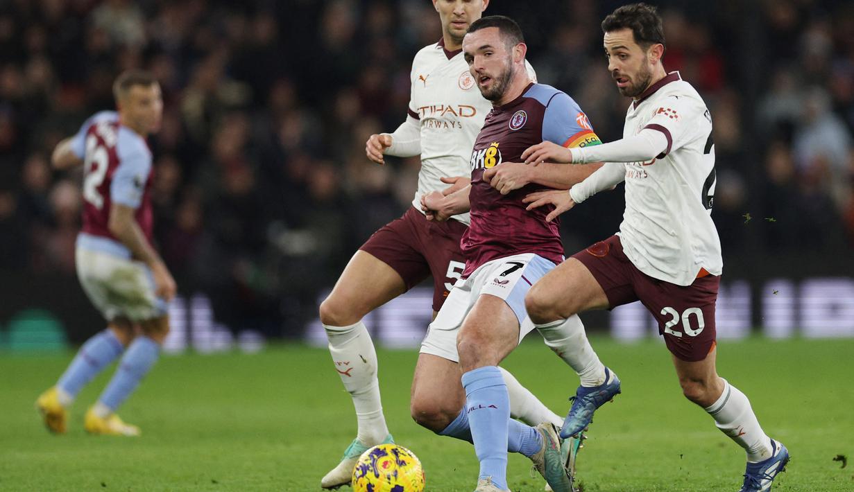 Pemain Aston Villa, John McGinn, berebut bola dengan pemain Manchester City, Bernardo Silva, pada laga lanjutan pekan ke-15 Premier League di Stadion Villa Park, Kamis (07/12/2023). (AFP/Adrian Dennis)