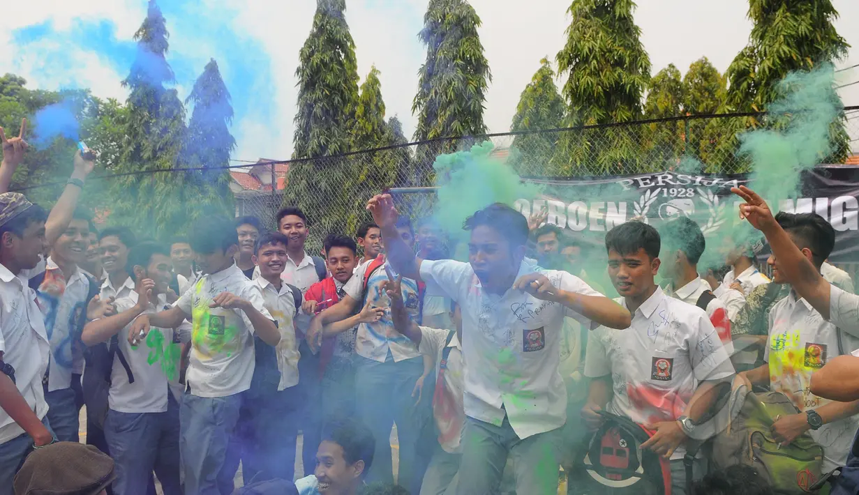 Sejumlah siswa SMK Kemala Bhayangkari 1 Jakarta, meluapkan kegembiraanya dengan melakukan aksi corat-coret seragam menggunakan cat warna setelah mengikuti Ujian Nasional (UN), Kamis (16/4/2015). (Liputan6.com/Herman Zakharia)