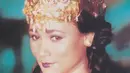 Suzzanna  tampil dengan atasan kemben keemasan serasi dengan aksesori kalung ular serta mahkota di rambutnya.  [@suzzannaofficial]