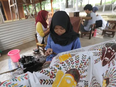 Perajin membuat batik tulis khas Betawi di rumah produksi Keluarga Batik Betawi, Setu Babakan, Jakarta Selatan, Minggu (10/3). Batik Betawi ini bermotif ondel-ondel, bunga manggar hingga Monumen Nasional (Monas). (merdeka.com/Arie Basuki)